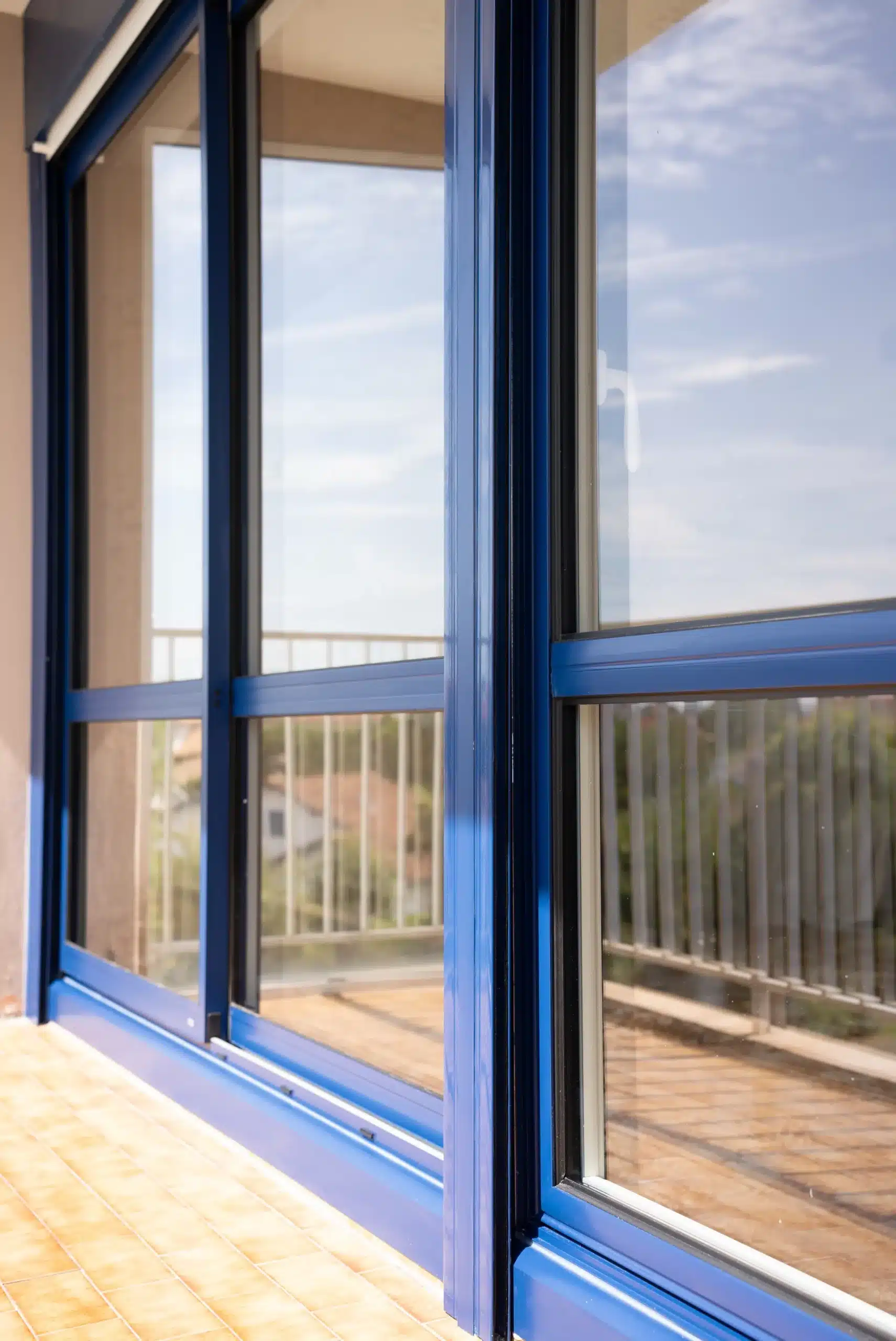 Détail d'une fenêtre coulissante aluminium bleu Adour PVC avec joint d'étanchéité et rail