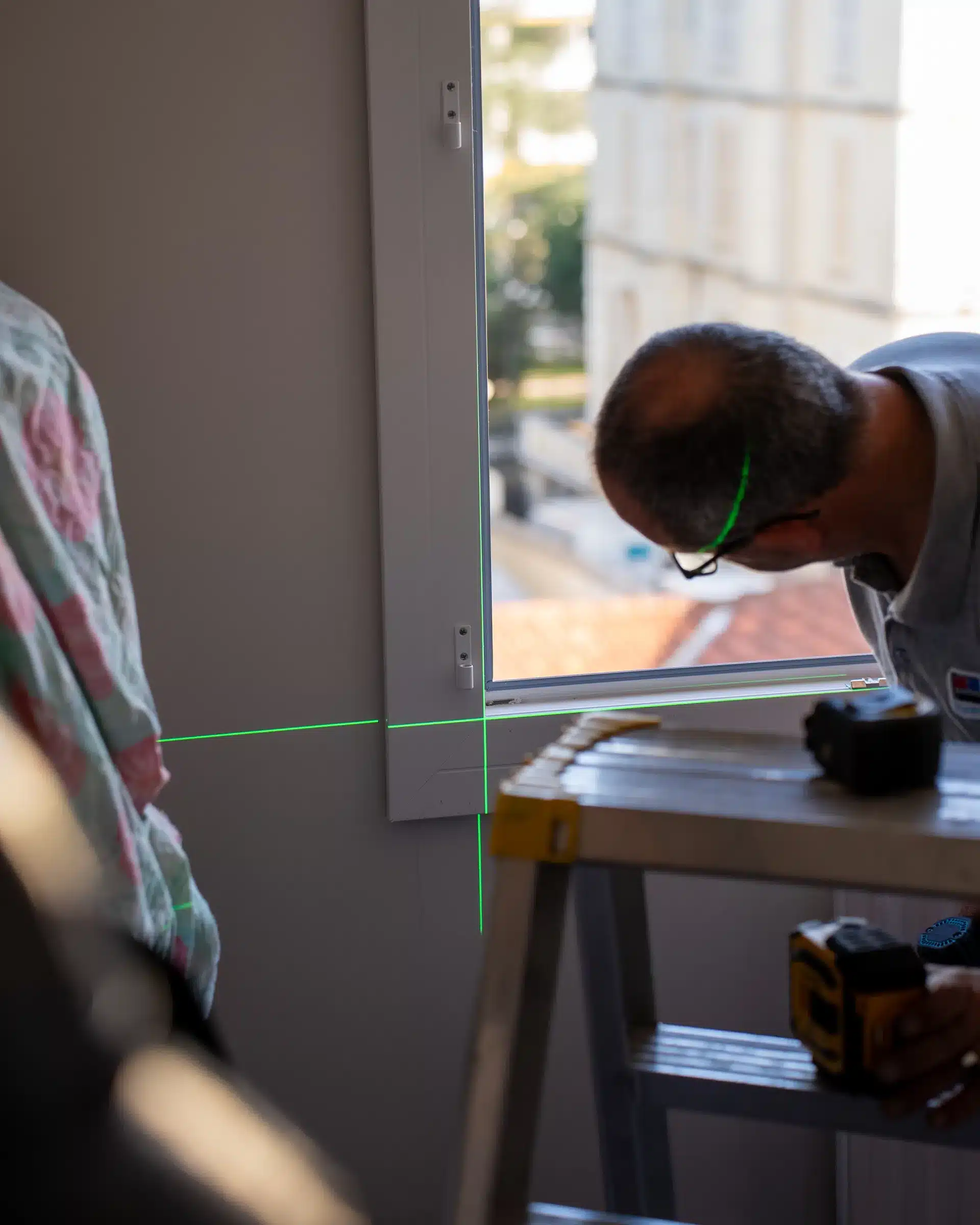 Contrôle d'aplomb d'une fenêtre au niveau laser vert lors de la pose par Adour PVC — Pays Basque